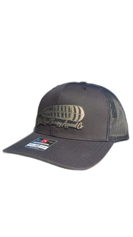 Black Richardson 112 trucker hat with gold leather feather patch